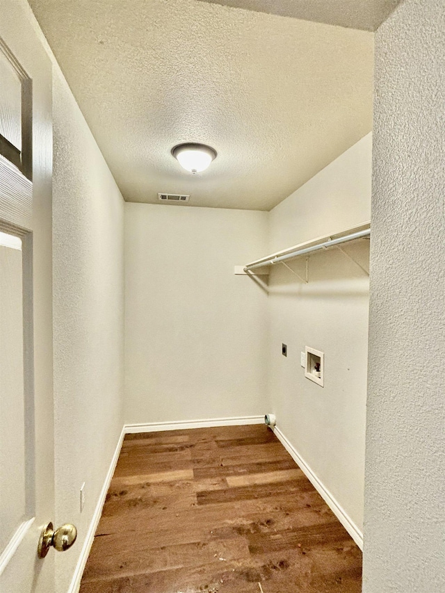 washroom featuring hookup for a washing machine, hardwood / wood-style floors, a textured ceiling, and hookup for an electric dryer