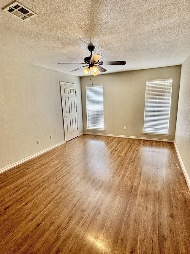 spare room with ceiling fan, a textured ceiling, and hardwood / wood-style flooring