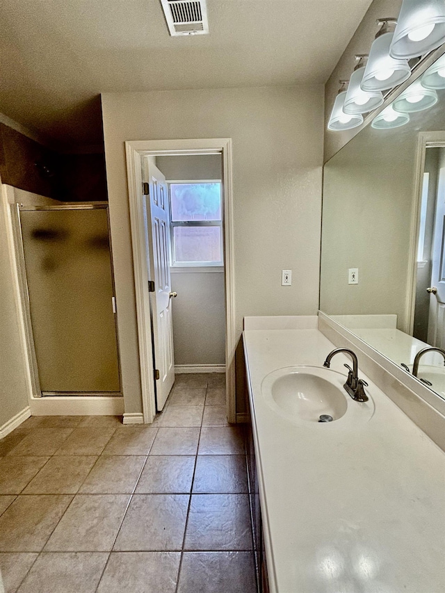 bathroom with tile patterned floors, vanity, and a shower with door