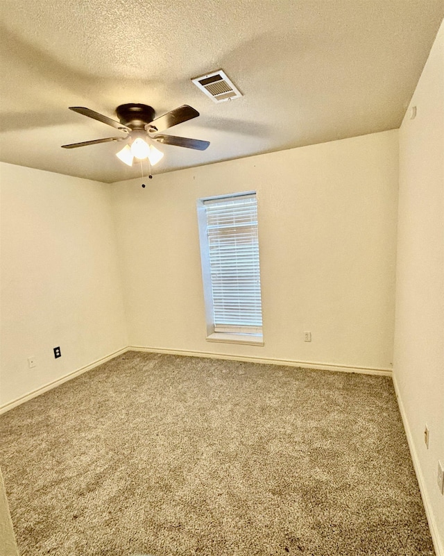 carpeted empty room featuring ceiling fan and a textured ceiling