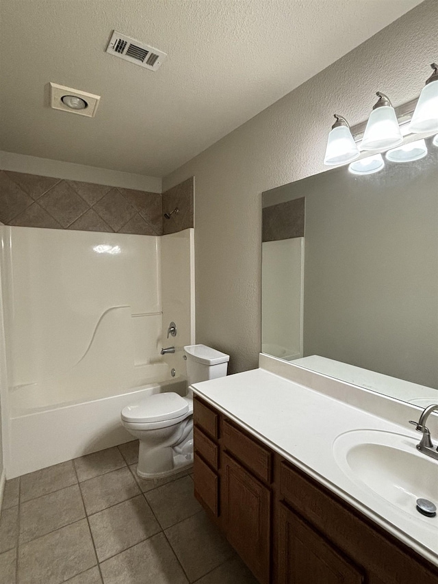 full bathroom featuring a textured ceiling, vanity, tile patterned flooring, toilet, and tiled shower / bath