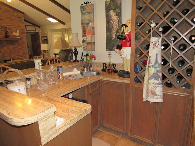 interior space with sink, light tile patterned floors, and lofted ceiling