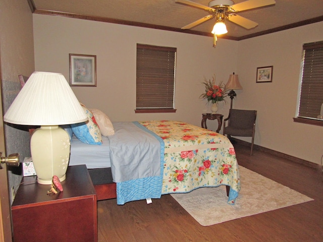 bedroom with ceiling fan, dark wood-type flooring, and ornamental molding