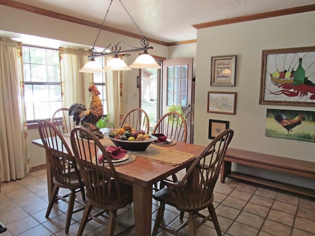 tiled dining space featuring ornamental molding and a textured ceiling