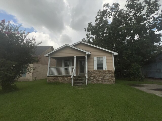 2007 Queen Ave, Nederland, TX 77627 - bungalow-style home featuring covered porch, a front lawn, and stone siding