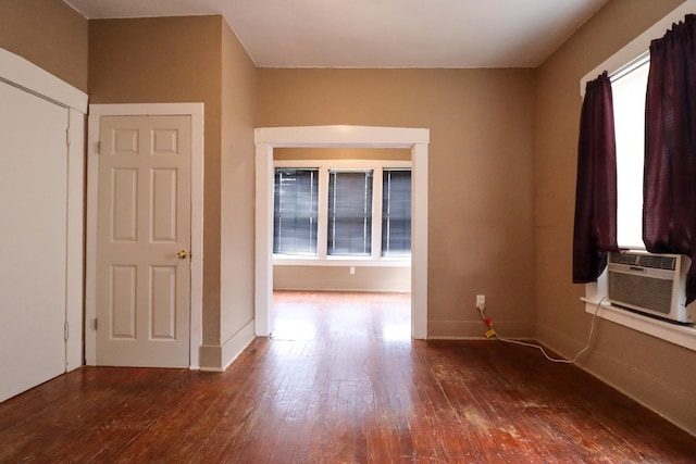 empty room with cooling unit, dark wood-type flooring, and a healthy amount of sunlight