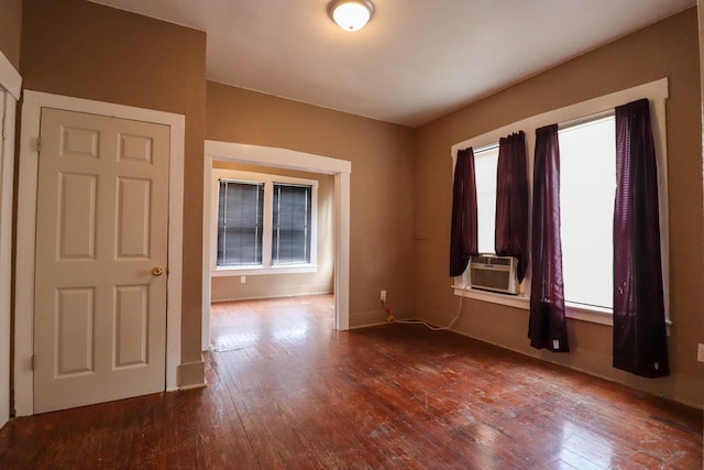 empty room featuring cooling unit and dark hardwood / wood-style flooring