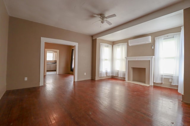 unfurnished living room featuring ceiling fan, wood-type flooring, and a wall mounted AC