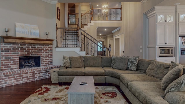 6570 Merrick Ln, Beaumont, TX 77706 - living room featuring ornamental molding, stairs, wood finished floors, a fireplace, and a high ceiling