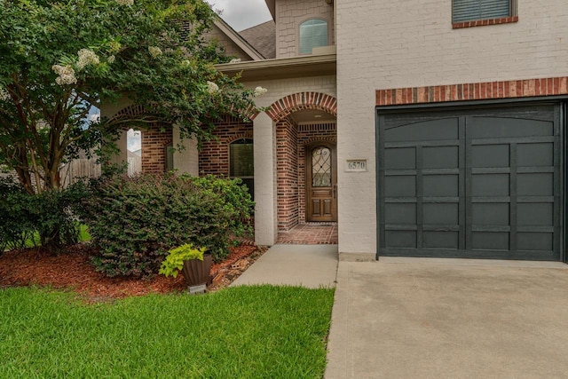 6570 Merrick Ln, Beaumont, TX 77706 - doorway to property with brick siding, driveway, and a garage