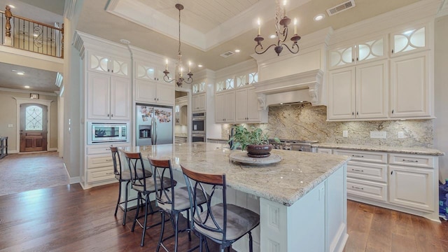 6570 Merrick Ln, Beaumont, TX 77706 - kitchen with appliances with stainless steel finishes, a chandelier, dark wood finished floors, ornamental molding, and white cabinetry