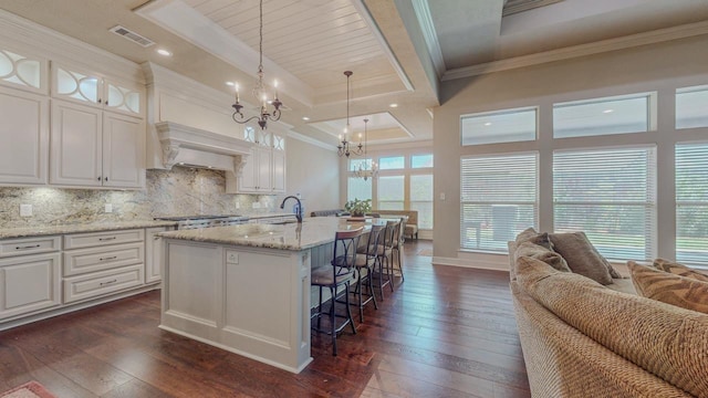 6570 Merrick Ln, Beaumont, TX 77706 - kitchen with a chandelier, dark wood-style flooring, decorative backsplash, white cabinetry, and ornamental molding