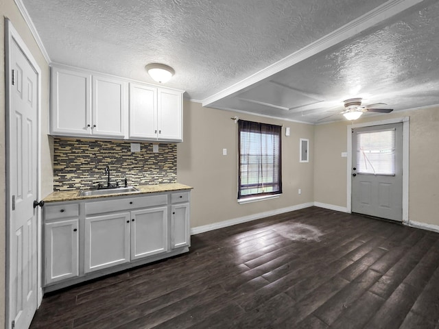 9570 Cumberland Dr, Beaumont, TX 77708 - kitchen featuring a textured ceiling, tasteful backsplash, healthy amount of natural light, dark wood-style flooring, and white cabinetry