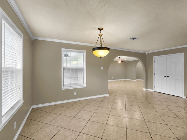 9570 Cumberland Dr, Beaumont, TX 77708 - spare room with ornamental molding, ceiling fan, arched walkways, and light tile patterned flooring
