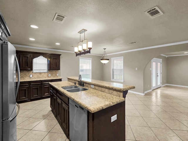 9570 Cumberland Dr, Beaumont, TX 77708 - kitchen with stainless steel appliances, light tile patterned floors, arched walkways, backsplash, and ornamental molding