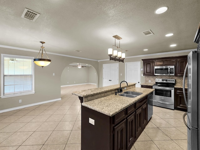 9570 Cumberland Dr, Beaumont, TX 77708 - kitchen featuring appliances with stainless steel finishes, light tile patterned flooring, decorative backsplash, ceiling fan, and an island with sink