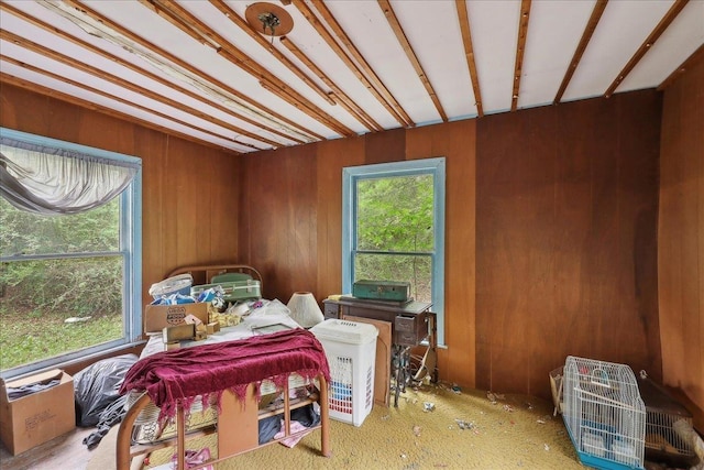 bedroom with wood walls and multiple windows