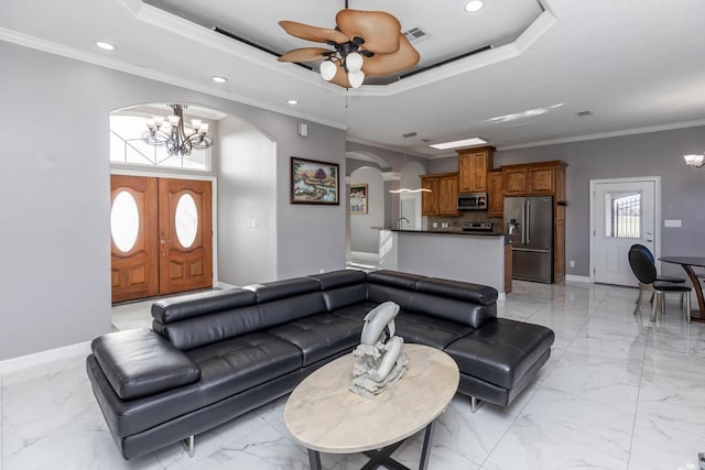 living room featuring arched walkways, marble finish floor, a raised ceiling, and visible vents