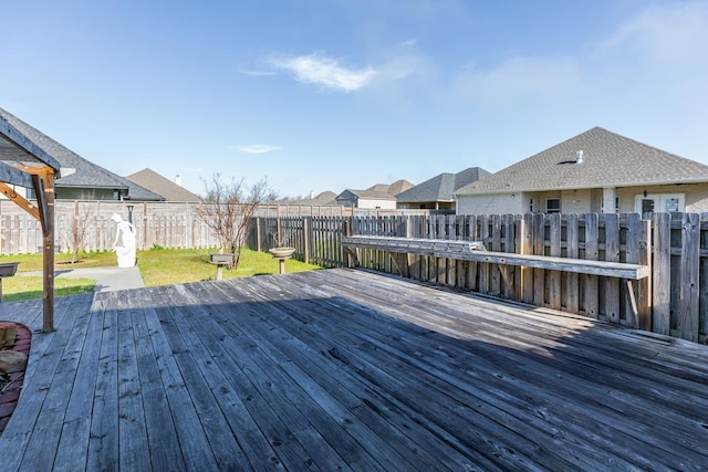 wooden terrace with a residential view, a fenced backyard, and a lawn