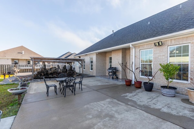 view of patio with area for grilling, fence, and a pergola