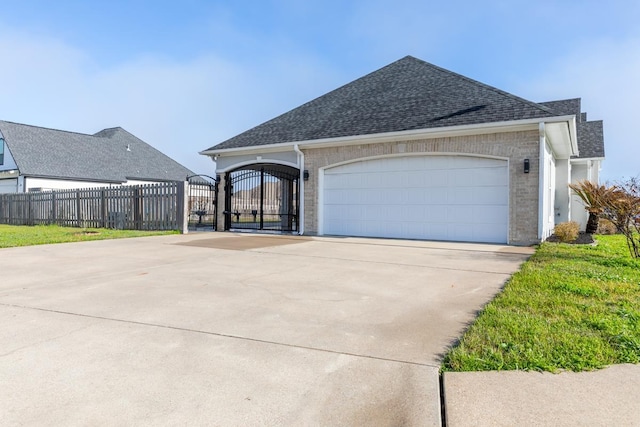 ranch-style house with a shingled roof, a gate, fence, and concrete driveway