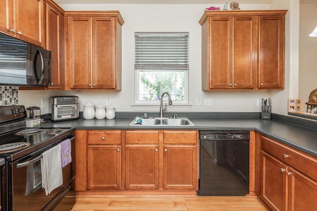 kitchen featuring light hardwood / wood-style floors, sink, and black appliances