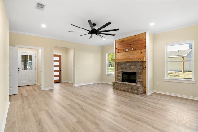 unfurnished living room with ceiling fan, a fireplace, light hardwood / wood-style floors, and ornamental molding