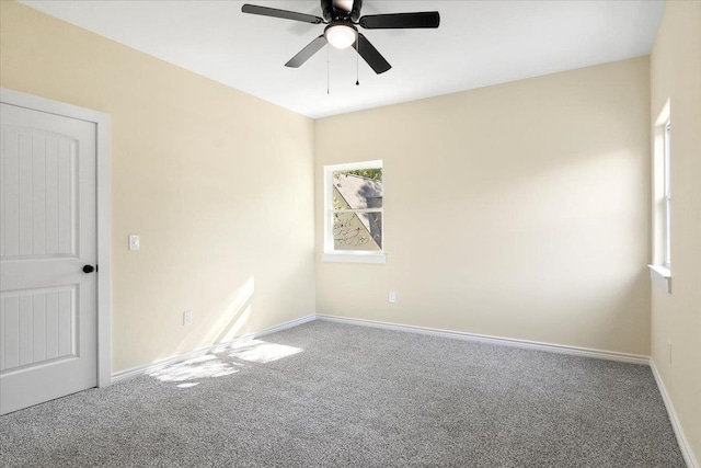 carpeted spare room featuring ceiling fan