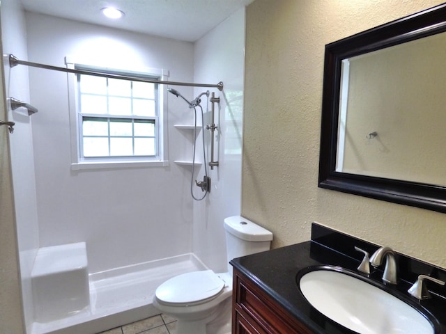5335 Idylwood St, Beaumont, TX 77703 - bathroom with a shower stall, toilet, vanity, tile patterned flooring, and a textured wall