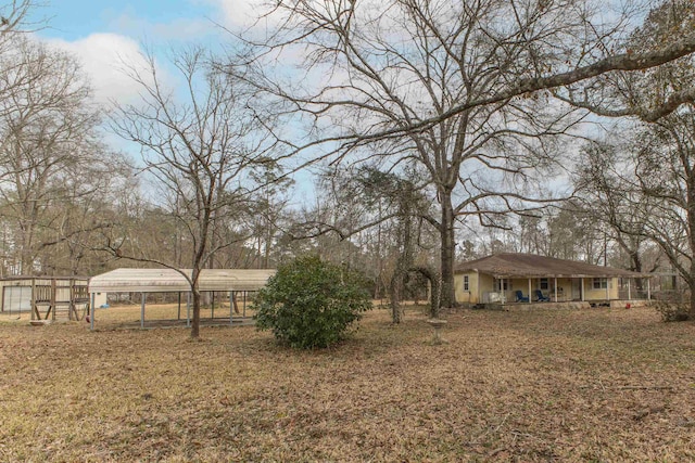 view of yard featuring a carport and a porch