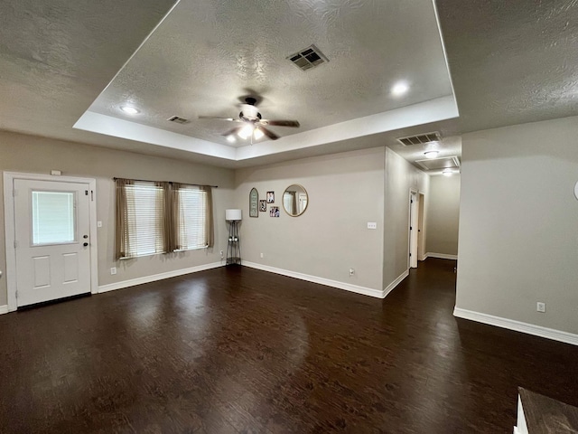 479 Reynolds Ln, Vidor, TX 77662 - unfurnished living room featuring a raised ceiling, baseboards, a textured ceiling, and wood finished floors
