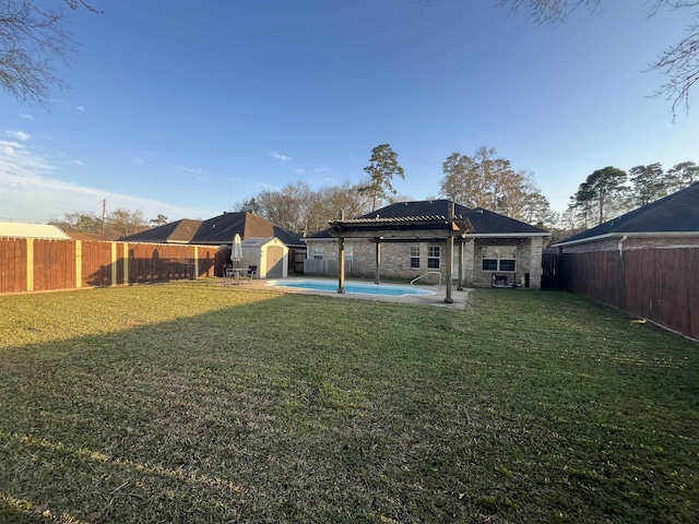 rear view of property featuring a fenced backyard, an outbuilding, a fenced in pool, and a yard