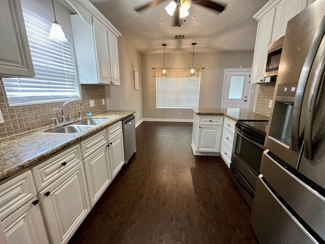 479 Reynolds Ln, Vidor, TX 77662 - kitchen featuring baseboards, white cabinets, tasteful backsplash, a sink, and stainless steel appliances