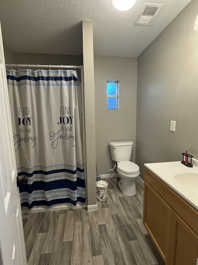 1445 Bahama Dr, Vidor, TX 77662 - full bathroom with vanity, wood finished floors, a textured ceiling, and a shower with shower curtain