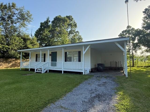 1445 Bahama Dr, Vidor, TX 77662 - view of front of house featuring driveway, a porch, a front lawn, and an attached carport