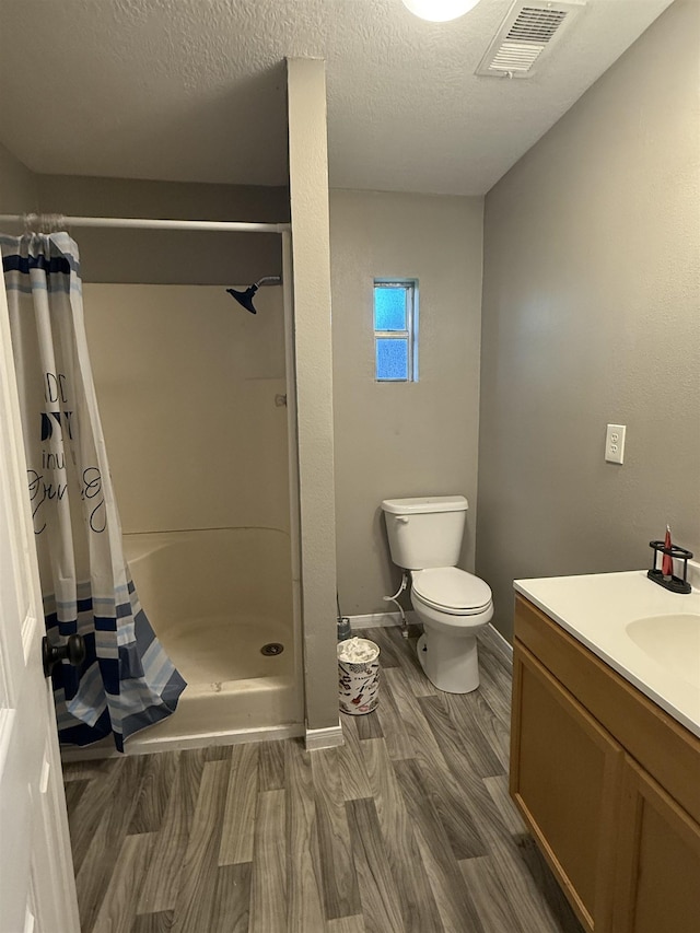1445 Bahama Dr, Vidor, TX 77662 - full bathroom featuring wood finished floors, vanity, a shower with curtain, and a textured ceiling