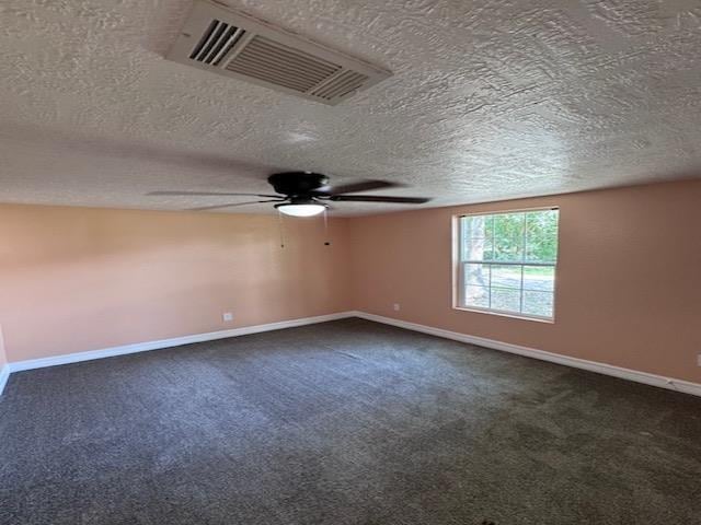 carpeted spare room with a textured ceiling and ceiling fan