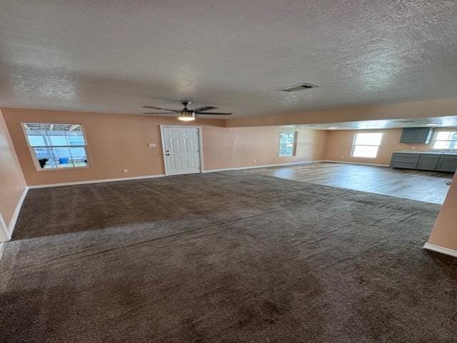 unfurnished living room featuring carpet, a textured ceiling, and ceiling fan