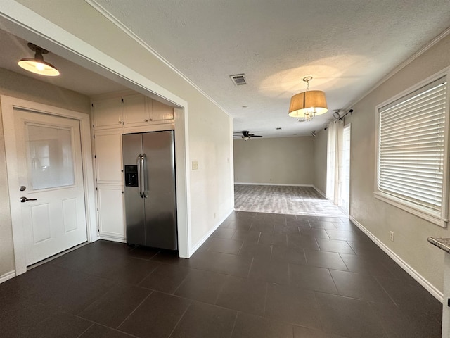 hallway with a textured ceiling and ornamental molding