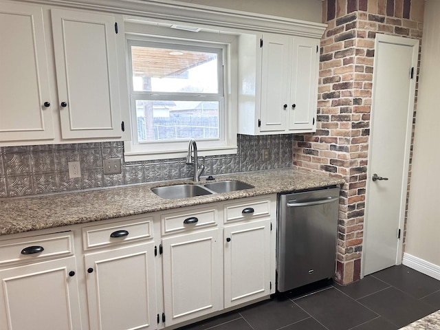 kitchen with stainless steel dishwasher, white cabinets, light stone counters, and sink