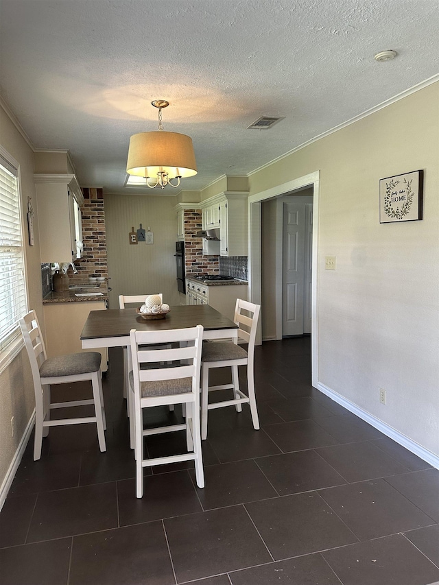 637 Ridgewood Dr, Port Neches, TX 77651 - dining area featuring crown molding, dark tile patterned flooring, and a textured ceiling