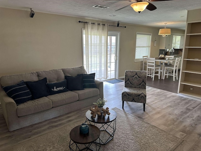 637 Ridgewood Dr, Port Neches, TX 77651 - living area featuring crown molding, a textured ceiling, ceiling fan, and light wood-style flooring