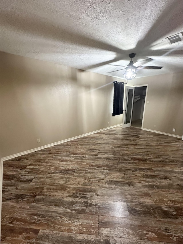 unfurnished bedroom featuring ceiling fan, dark hardwood / wood-style floors, and a textured ceiling