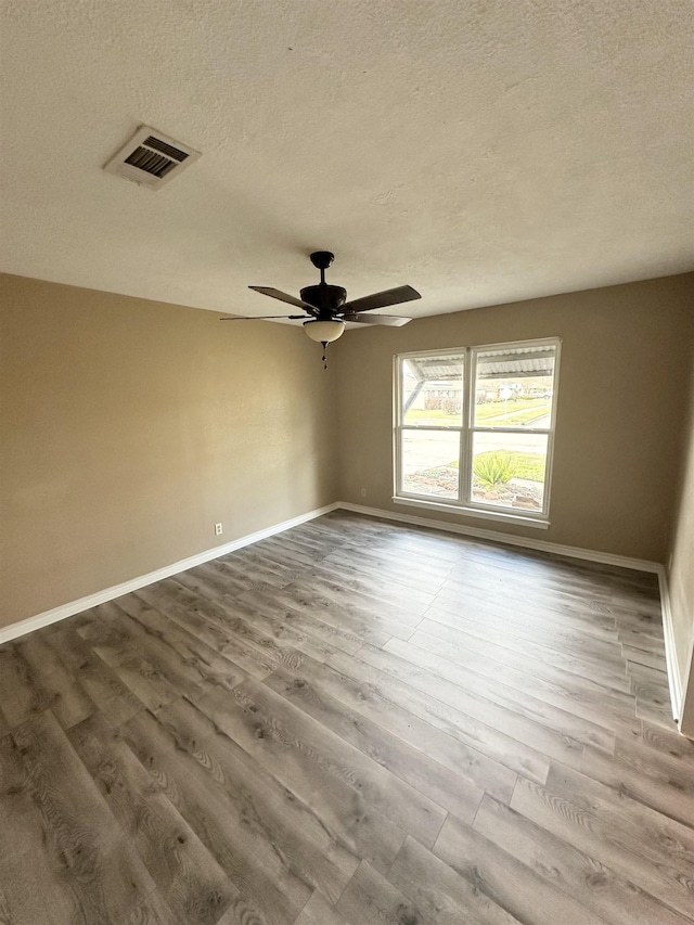 unfurnished room with a textured ceiling, ceiling fan, and wood-type flooring