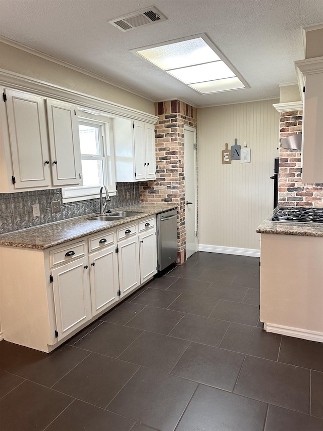 kitchen featuring backsplash, sink, white cabinetry, dark tile patterned floors, and stainless steel appliances