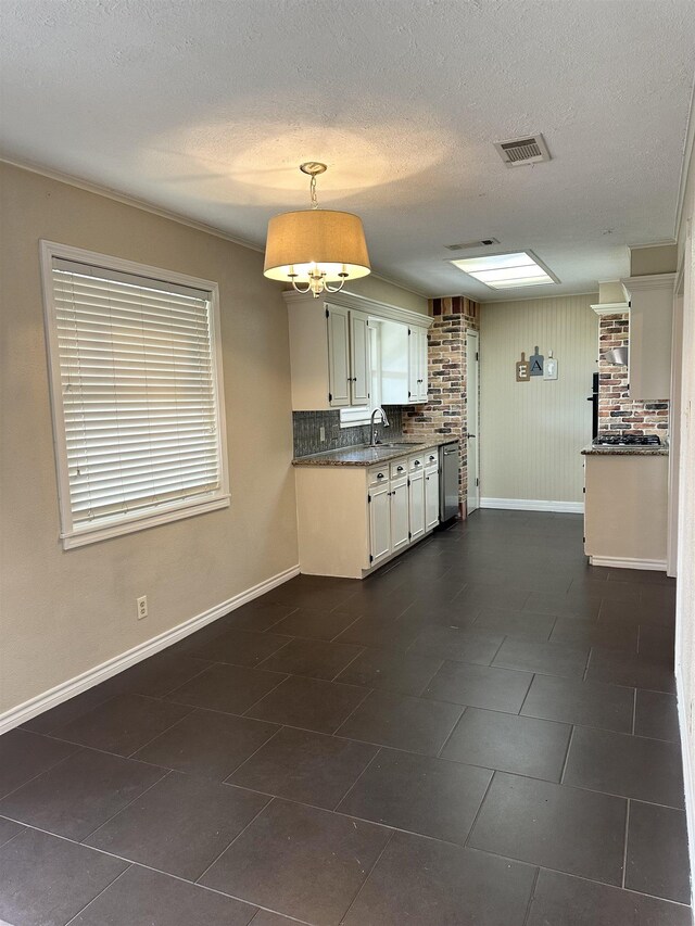 637 Ridgewood Dr, Port Neches, TX 77651 - kitchen with baseboards, a sink, dishwasher, white cabinetry, and dark tile patterned floors