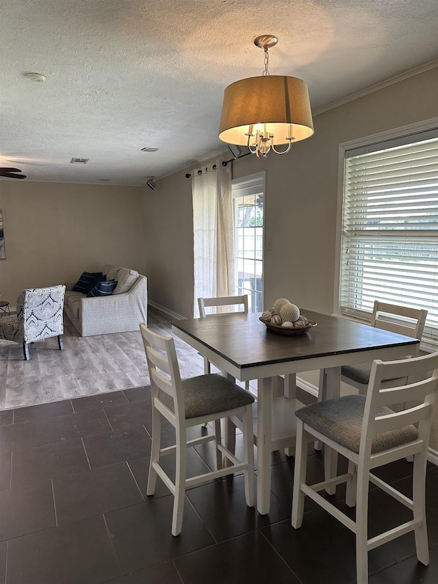 637 Ridgewood Dr, Port Neches, TX 77651 - tiled dining space featuring a textured ceiling and a chandelier