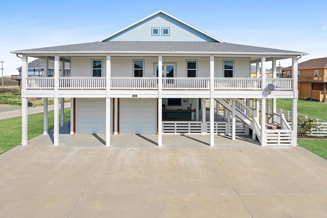 raised beach house featuring a porch and a garage