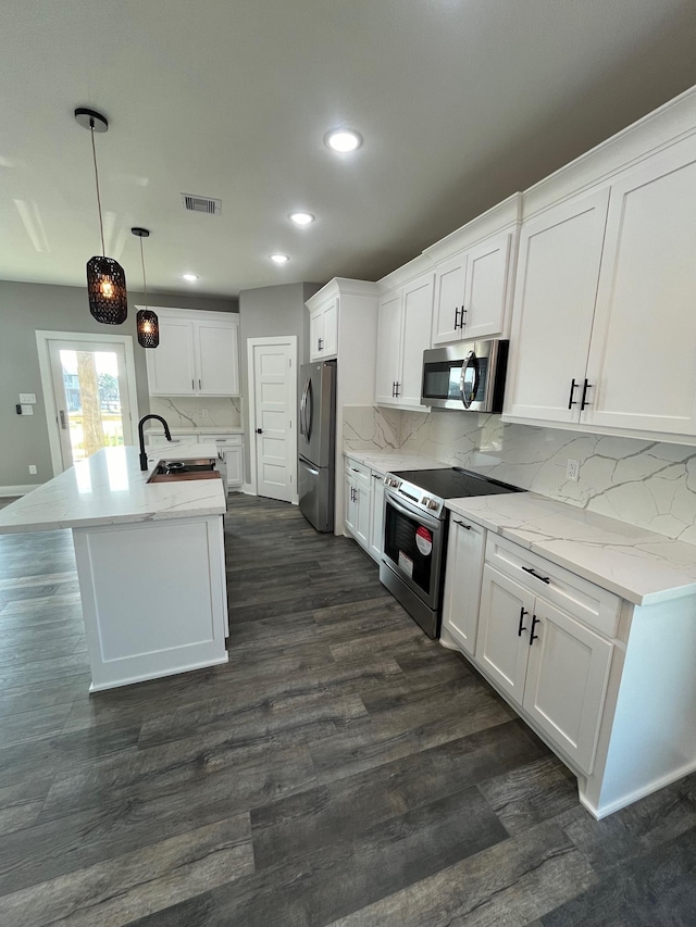 kitchen featuring backsplash, decorative light fixtures, white cabinets, and stainless steel appliances