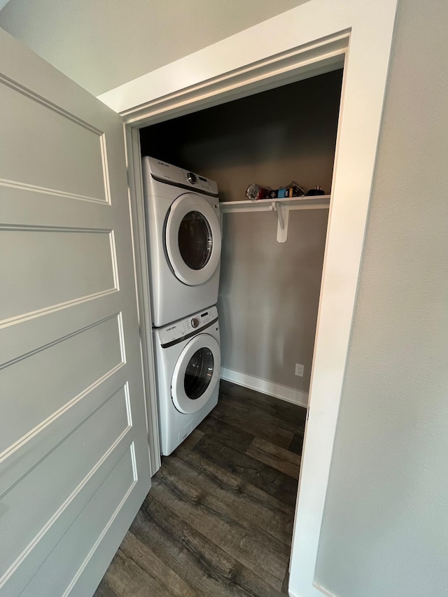 clothes washing area with stacked washer / dryer and dark hardwood / wood-style flooring